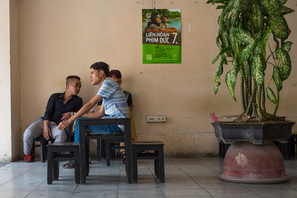 Three young men enjoying Vietnamese coffee and cigarettes on a hot Hue afternoon.